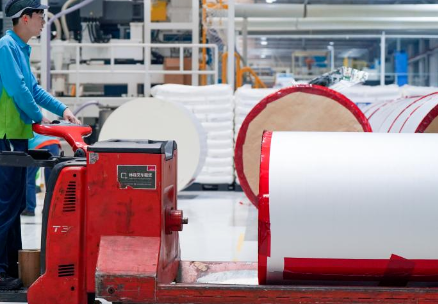 包裝公司工人使用電動(dòng)搬運(yùn)車搬運(yùn)包裝材料